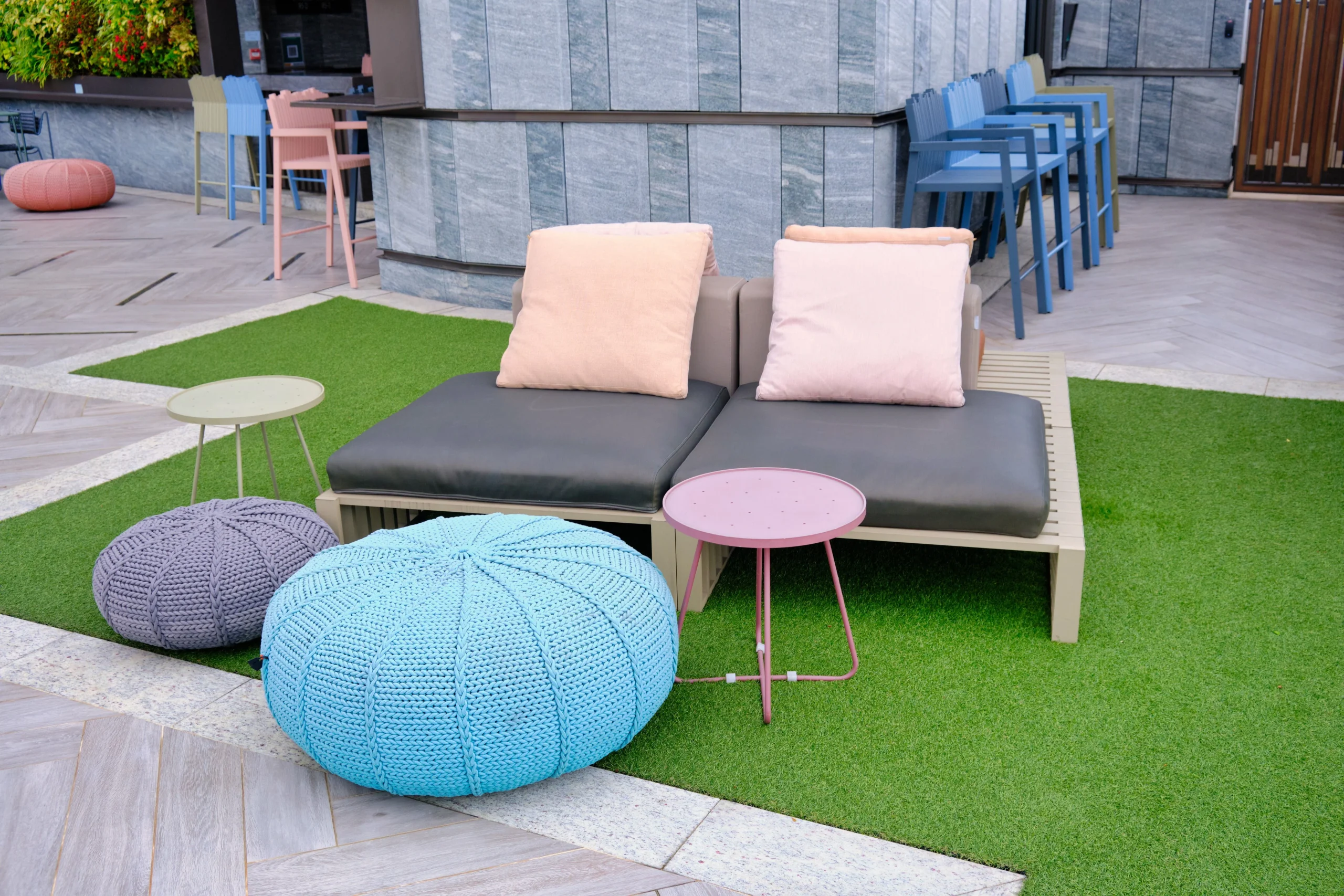 Outdoor lounge seating on artificial turf with modern cushions and colorful accents